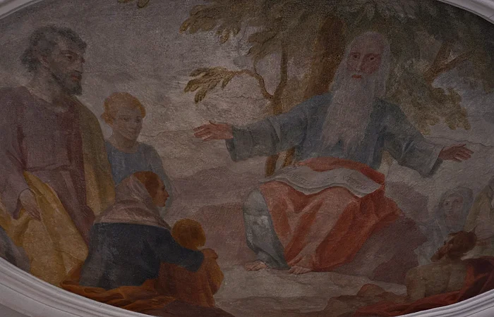 Fresko mit älterem Mann mit langem Bart, der auf Felsen sitzt und mehreren Menschen zuhört.